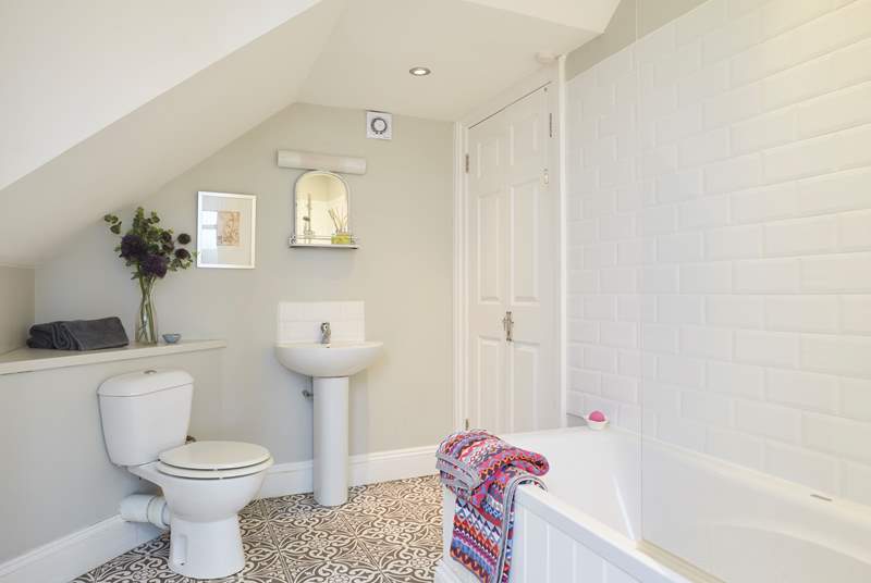 The spacious family bathroom with bath and shower over.