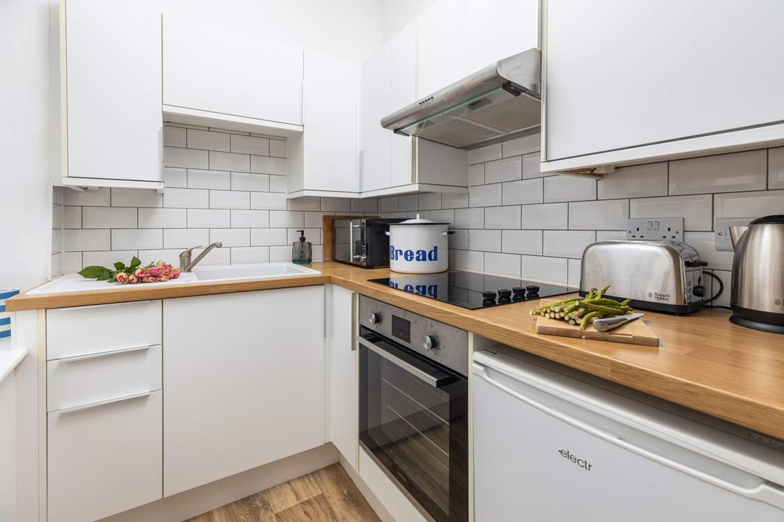 The bright kitchen may be small but is equipped with all you will need for your stay.