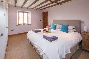 The master bedroom offers this beautifully inviting super king-size bed.