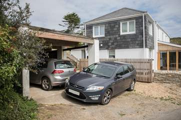 There is parking for two cars. However, with some very experienced parking skills, you could squeeze two small cars into the carport, leaving you space for a third in front.