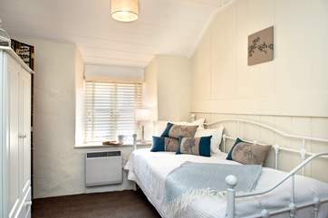 The pretty day bed adorned with lovely linen cushions provides flexible sleeping arrangements.