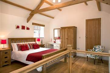 The bedroom has a high vaulted ceiling.
