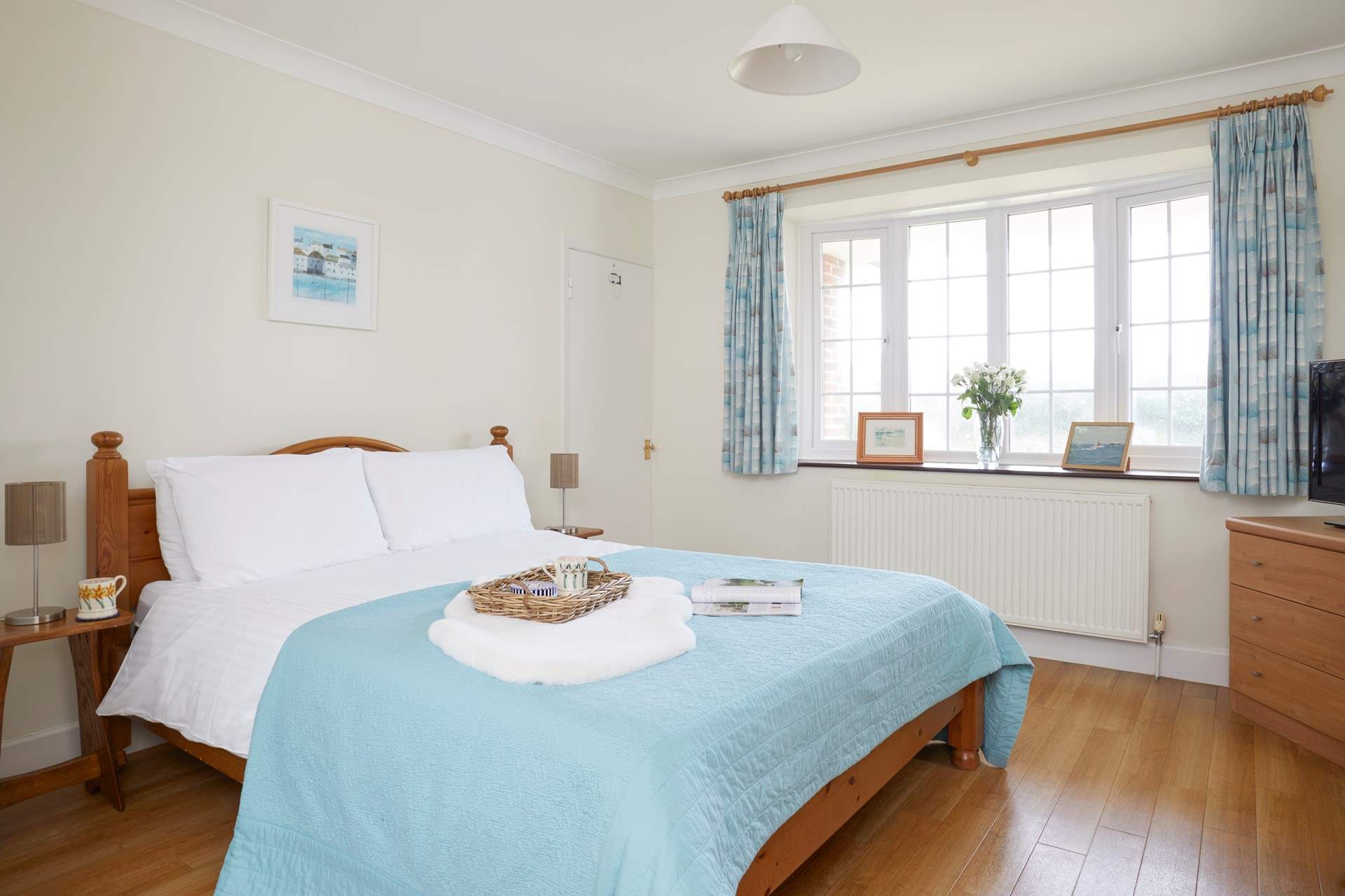 The lovely master bedroom is beautifully furnished in calm pastel shades. 