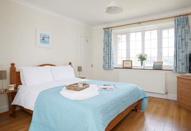 The lovely master bedroom is beautifully furnished in calm pastel shades. 