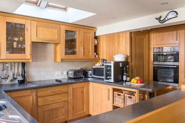 The kitchen is well-equipped, and the utility-room is through the sliding door.