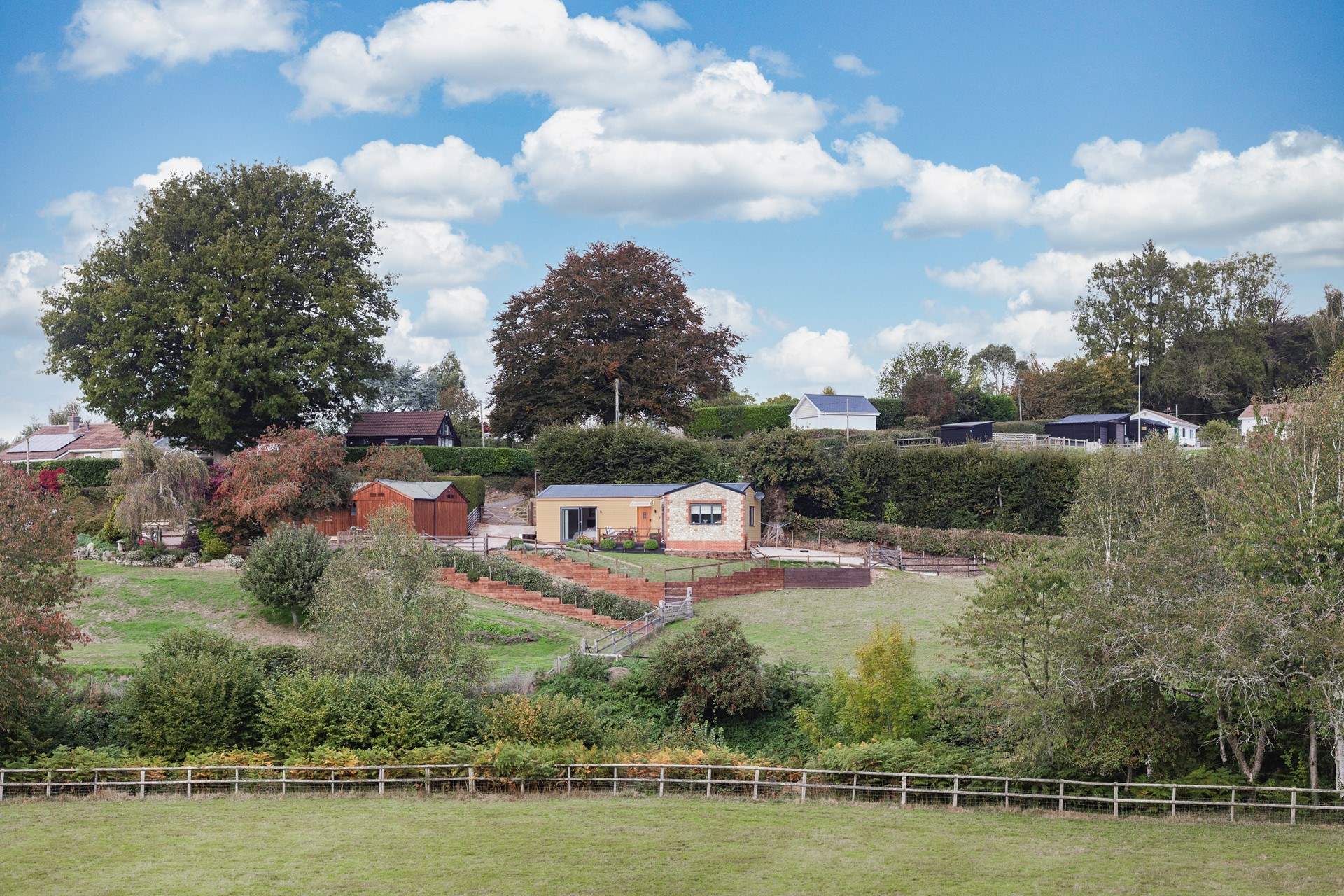 Cider Barn nestles into the hillside, the owner's home is to the left of the barn. Landscaping will include fencing to keep little ones safe.