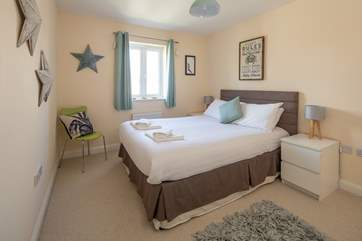 The master bedroom with en suite shower room is light, airy, and spacious.