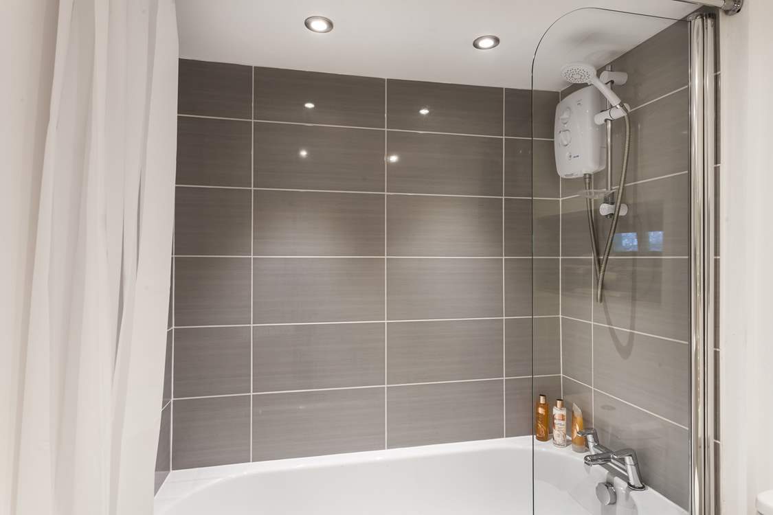 The family bathroom has a bath with a fitted shower over.