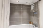 The family bathroom has a bath with a fitted shower over.