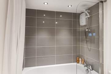 The family bathroom has a bath with a fitted shower over.