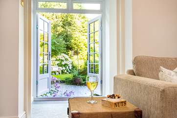 Double doors lead out from the sitting-room through the sun-room to the garden.