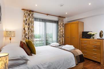 The master bedroom has patio doors leading out onto the decked outside area.