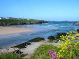 Glendorgal (seen top left) sits on its own private 17 acre headland beside Porth Beach.