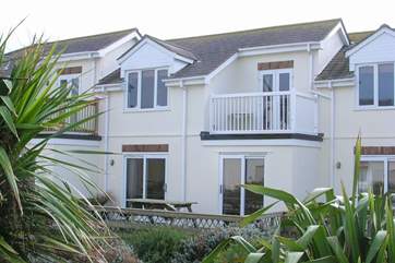 The rear of 2 Glendorgal, showing the lovely top floor balcony, and patio doors which lead from the bedrooms onto the decked area. Perfect for an al fresco dinner.