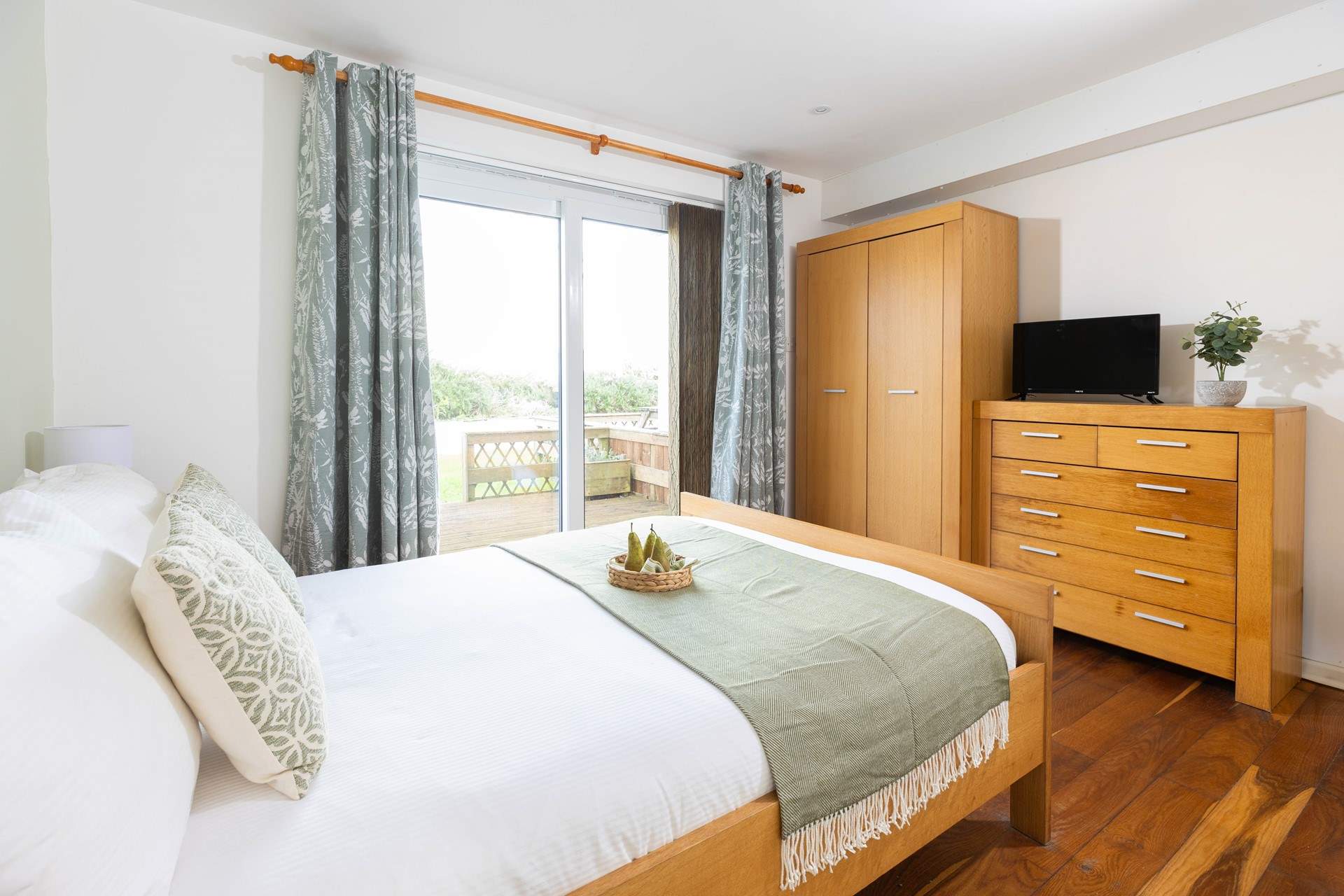 This main bedroom has a double bed and en suite shower-room plus a glimpse of the headland (Bedroom 1). 