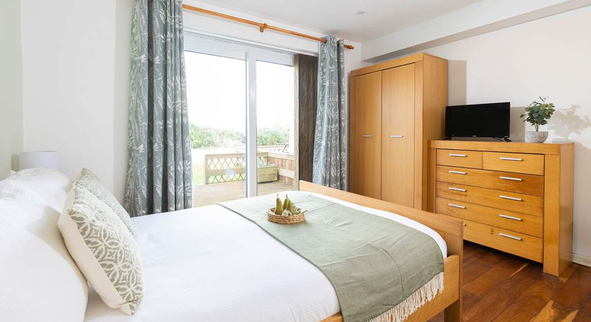 This main bedroom has a double bed and en-suite shower room and a glimpse of the headland (Bedroom 1). 