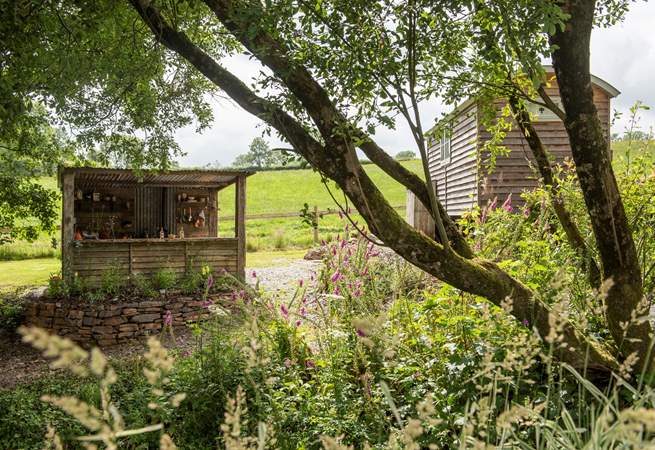 There's a rustic outdoor kitchen behind the hut. 