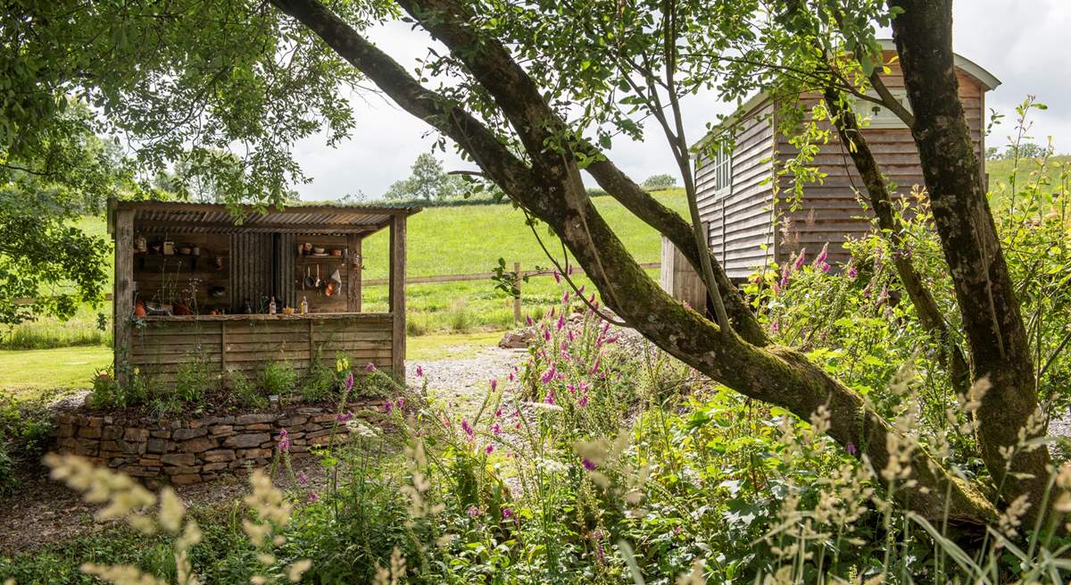 There's a rustic outdoor kitchen behind the hut. 