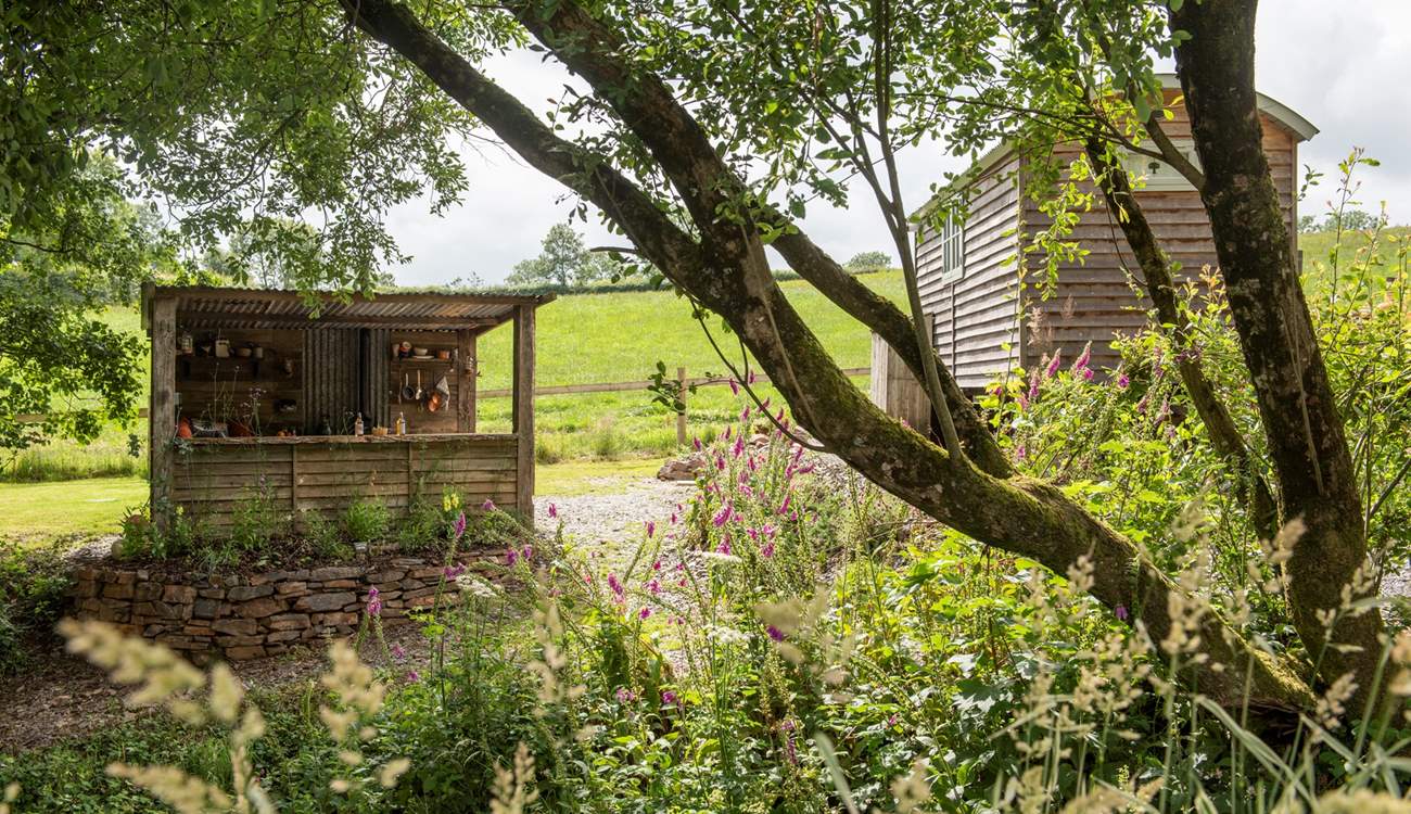 There's a rustic outdoor kitchen behind the hut. 