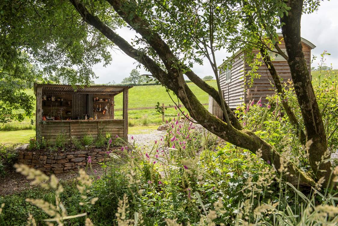 There's a rustic outdoor kitchen behind the hut.