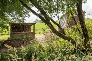 There's a rustic outdoor kitchen behind the hut.