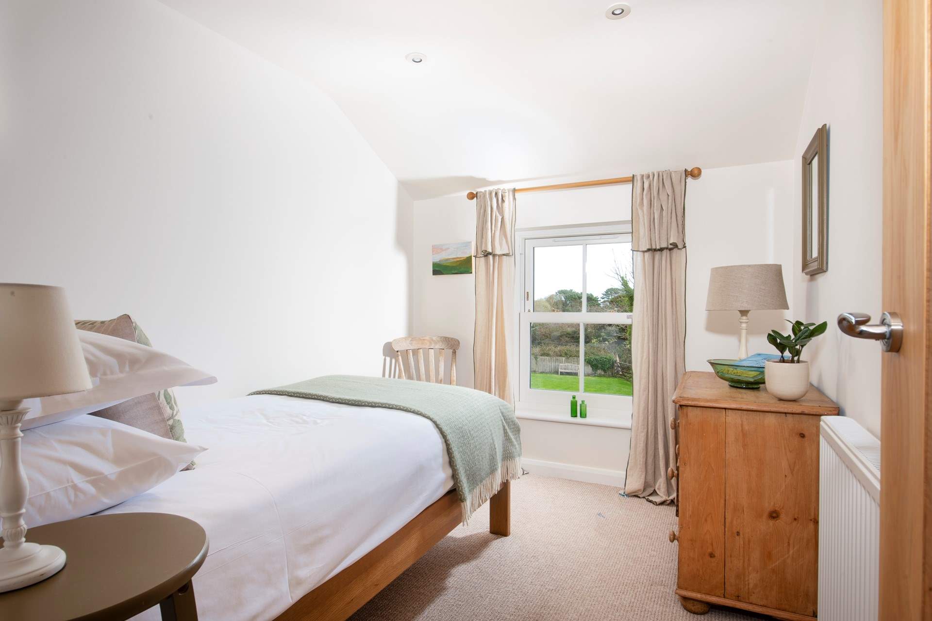 Bedroom 3 is soft and soulful with garden views.