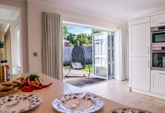 There are bi-fold doors from the kitchen leading to the patio and garden area.