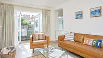 The cosy sitting-room has patio doors that open up to the enclosed garden.