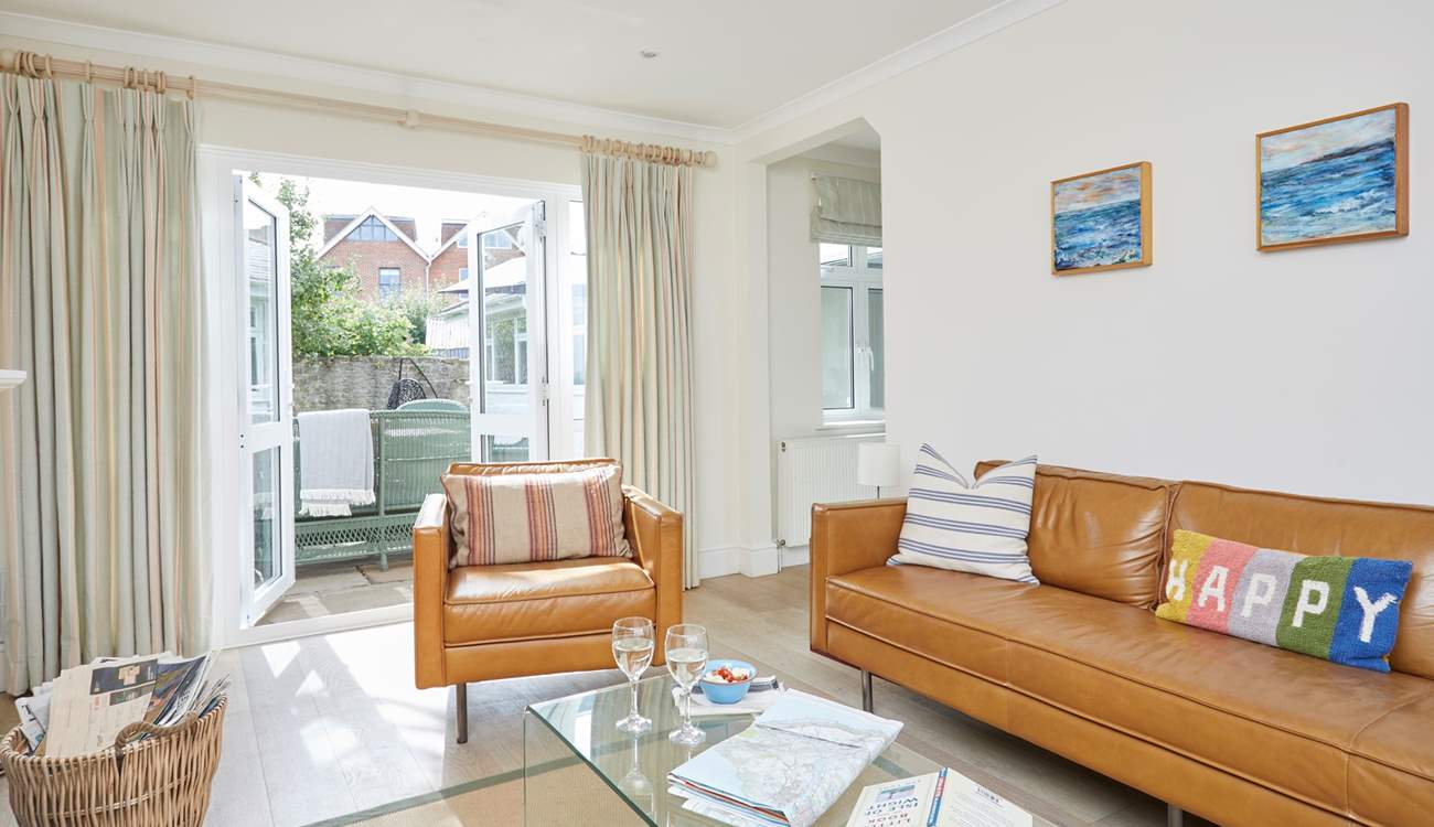 The cosy sitting-room has patio doors that open up to the enclosed garden.