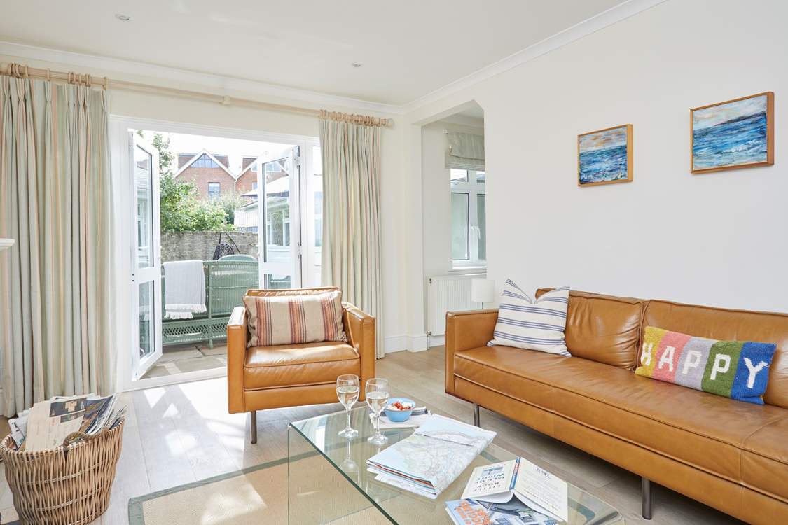 The cosy sitting-room has patio doors that open up to the enclosed garden.