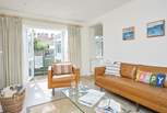 The cosy sitting-room has patio doors that open up to the enclosed garden.