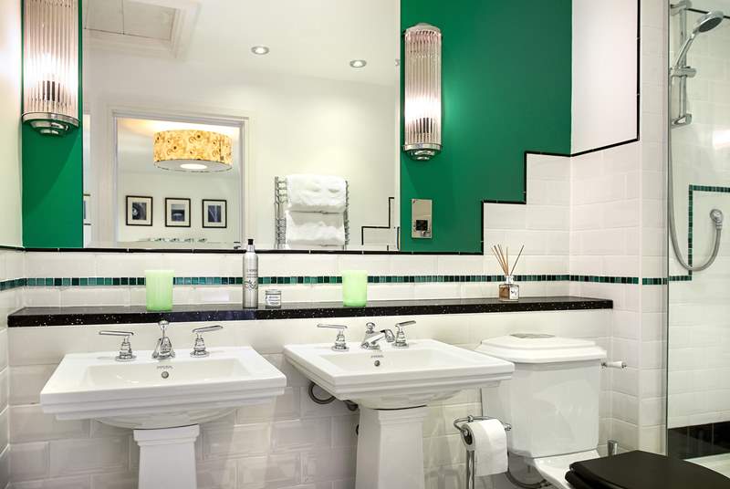 The Art Deco theme continues in the en suite shower-room but things have moved on from the Art Deco era with double sinks and a stylish shower.