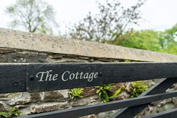 A five-bar wooden gate encloses the parking-area in front of the cottage.