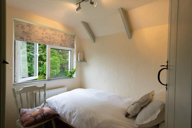 The single bedroom looks out over the large garden and across the fields beyond it.