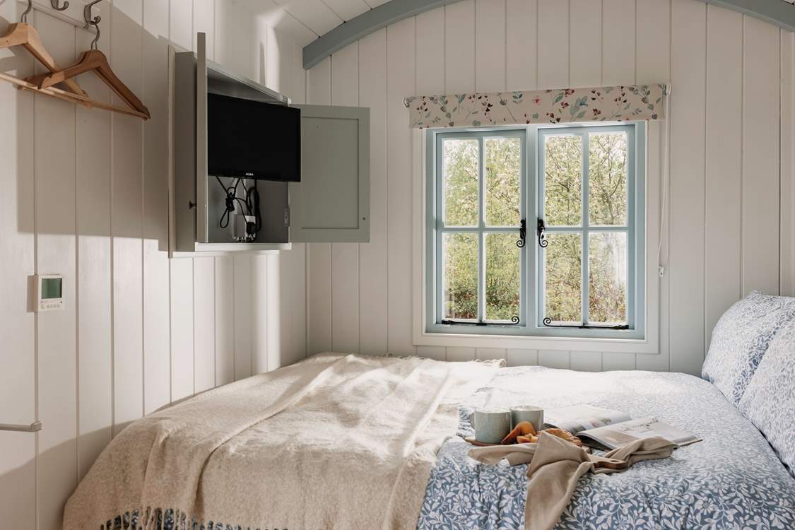 The TV cleverly tucks away into the wall-mounted cabinet.