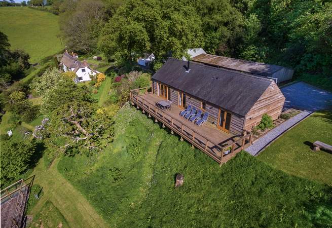 Larch Barn in the foreground with the owner's white Listed cottage in the background.