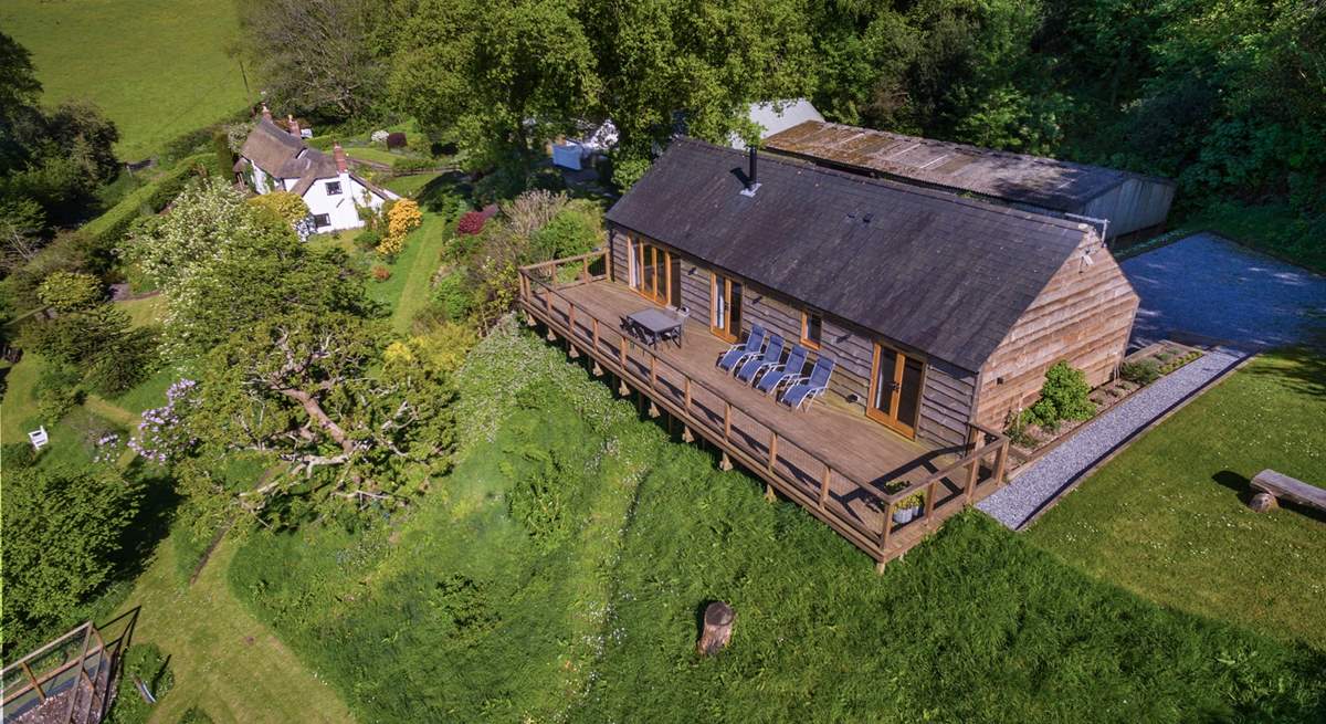 Larch Barn in the foreground with the owner's white Listed cottage in the background.