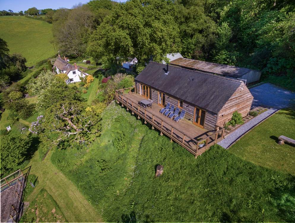 Larch Barn in the foreground with the owner's white Listed cottage in the background.