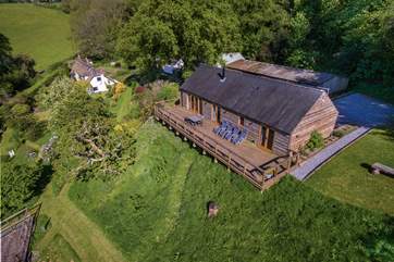 Larch Barn in the foreground with the owner's white Listed cottage in the background.