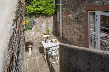 Looking down the steps from the top patio area to the ground floor sitting area and patio doors.