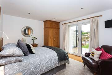 This bedroom has patio doors leading out on to the rear garden.