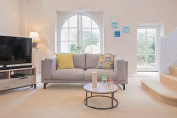 Doors from the living-room lead out to the patio and garden area with an outdoor table and chairs.