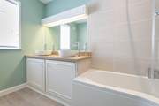 The en suite bathroom to bedroom 1 has twin wash-basins.