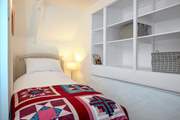 The sweet single room with plenty of shelf space.