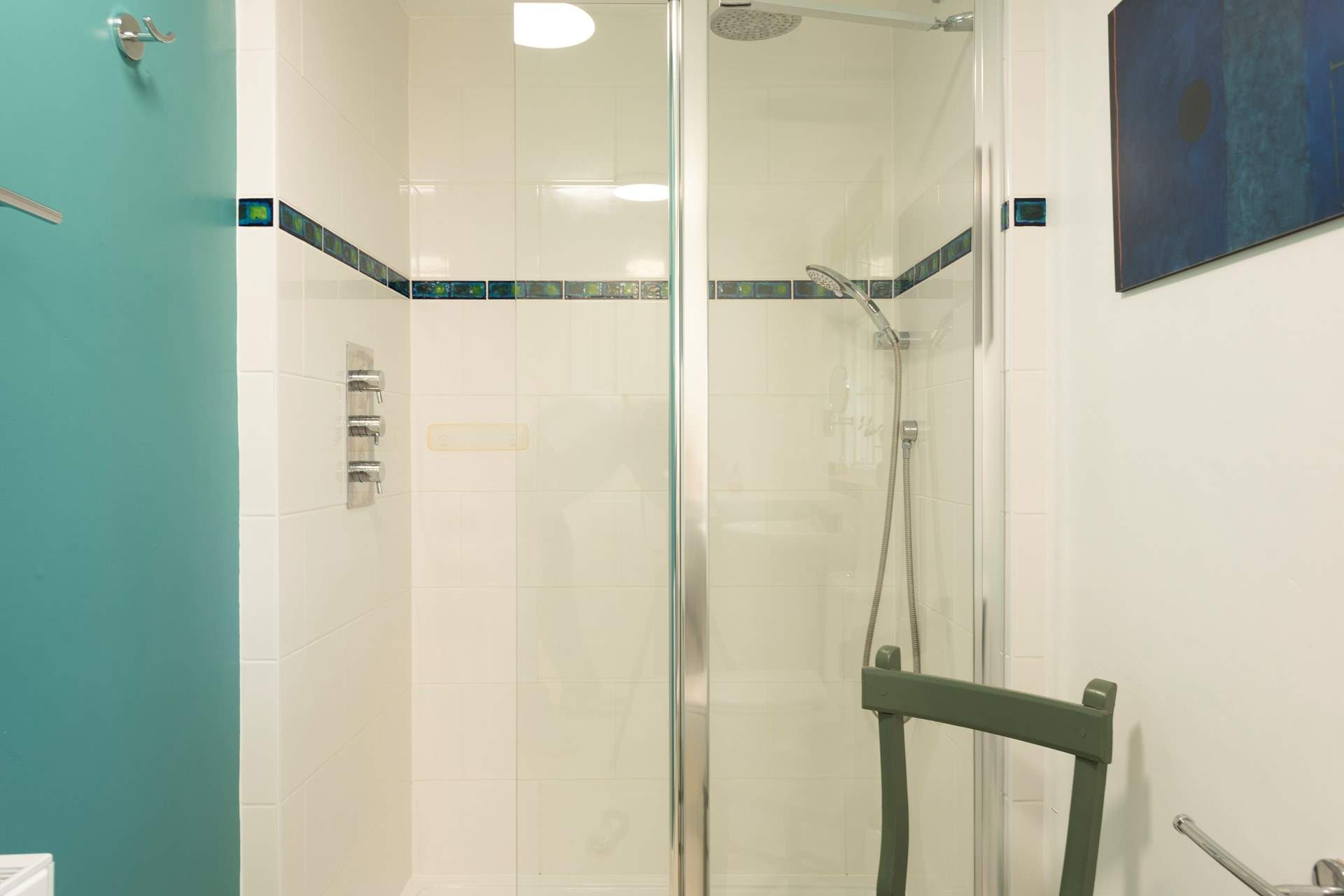 The shower cubicle has a hand held shower attachment.