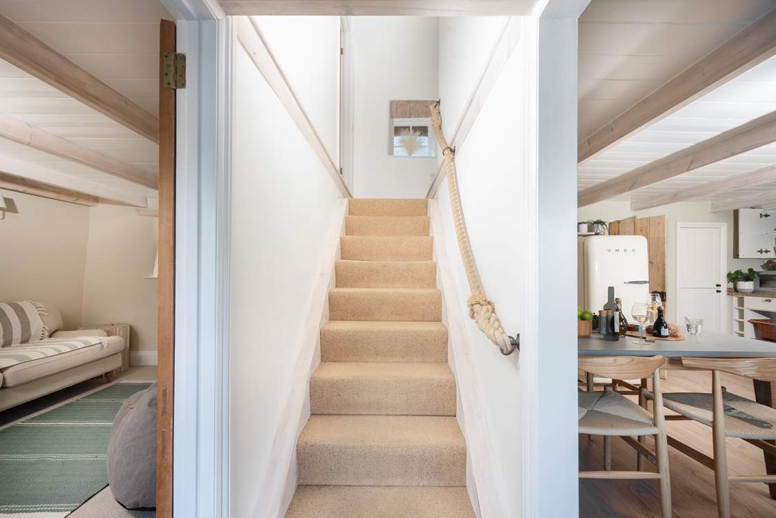 Traditional steep stairs take you to the beautifully appointed bedrooms and bathroom.