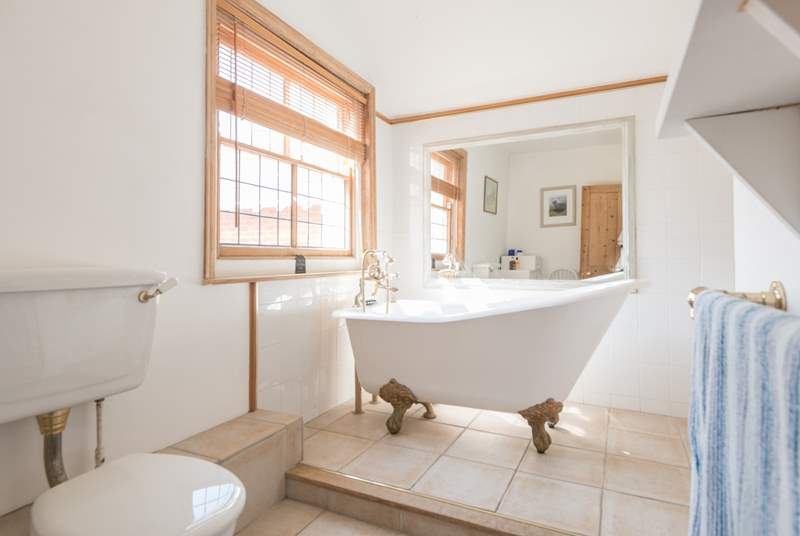 The spacious family bathroom has a roll-top bath and double wash-basin