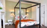 The bedroom has a contemporary four-poster bed. - Thumbnail Image