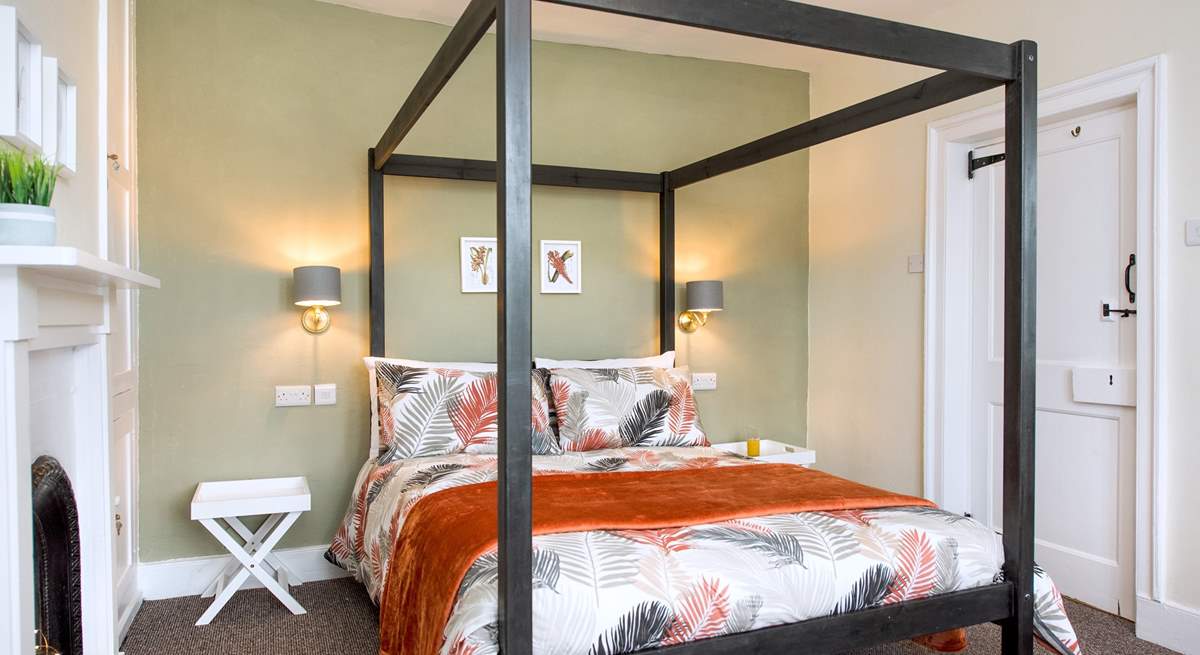 The bedroom has a contemporary four-poster bed.