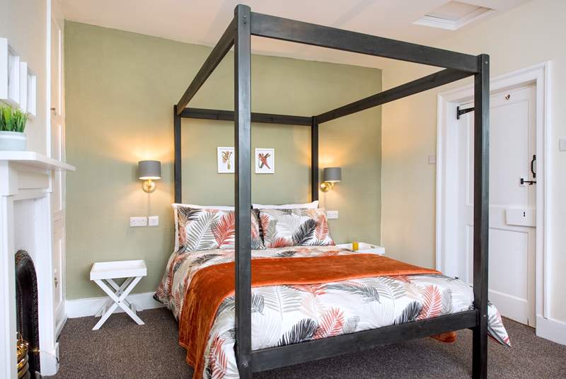 The bedroom has a contemporary four-poster bed.